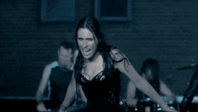 a woman in a black corset is standing in front of a group of men
