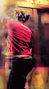 a person in a red shirt is standing in front of a yellow wall