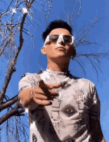 a man wearing sunglasses and a shirt with an eye on it