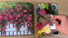 a painting of flowers is being painted on a canvas by a person