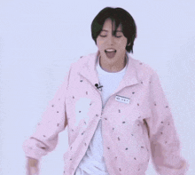 a man wearing a pink jacket with a name tag that says ' aee ' on it