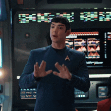 a man in a star trek uniform stands in front of a large screen that says ' discovery ' on it