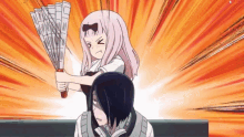 a girl is holding a fan over a man 's shoulder .