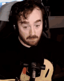 a man wearing headphones is talking into a microphone .