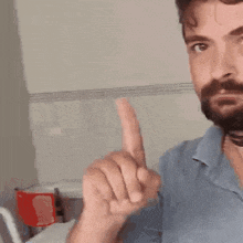 a man with a beard is pointing his finger at something
