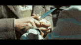 a man is holding a knife over another man 's wrist