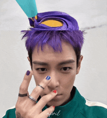 a man with purple hair is wearing a green jacket with april written on the bottom