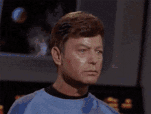 a close up of a man 's face with a green shirt