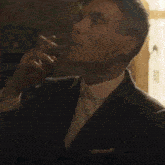 a man in a suit and tie is standing in front of a window