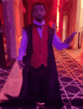 a man in a red vest and bow tie is dancing in a hallway .