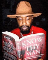 a man in a hat is reading a book titled know thy man