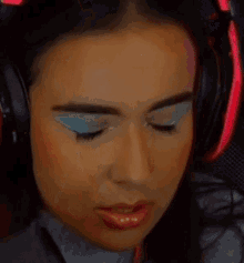 a close up of a woman wearing headphones and makeup .