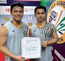 two athletes standing in front of a yonex sign