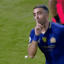 a soccer player wearing a blue shirt that says etihad