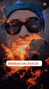 a man wearing sunglasses and a blue beanie is surrounded by fire