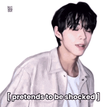a man in a white jacket and white shirt says i pretends to be shocked