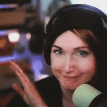 a woman wearing headphones and a hat is smiling and clapping