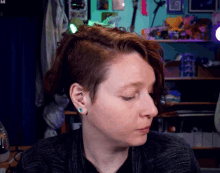 a woman with a piercing in her ear is looking at the camera