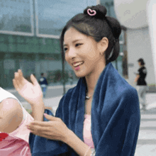 a woman with a heart in her hair is smiling and waving