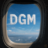 an airplane window with the word dgm written in the sky