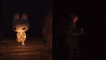 a stuffed bunny is lit up in the dark next to a woman holding a flashlight