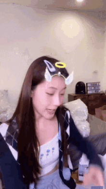 a woman wearing a headband with angel wings and a halo on it