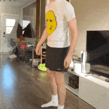 a man wearing a t-shirt with a yellow face on it