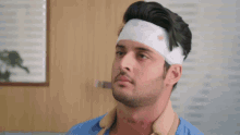 a man with a bandage on his head looks to the side