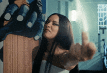 a woman giving the middle finger in front of a painting of a gorilla