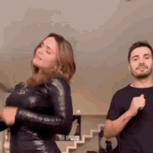 a man and a woman are dancing in a living room