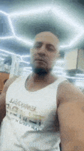 a man with a beard is taking a selfie in a gym .