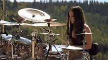 a woman is playing a drum set with a cymbal that says ' a ' on it