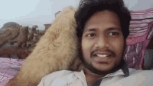 a man with a beard is laying on a bed with a cat