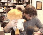 a man holds a stuffed animal in front of a microphone with thinkjules written on the bottom