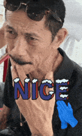 a man wearing sunglasses and a black shirt has the word nice written on his face