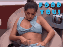 a woman in a blue top is sitting in a chair with the words food you behind her