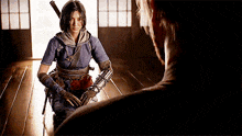 a man and a woman are standing next to each other in a dark room . the woman is holding a sword .