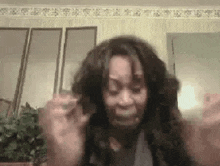 a woman with long hair is making a funny face while sitting in a living room .