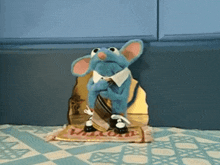 a blue mouse is sitting on a welcome rug