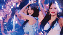 a woman in a blue dress is dancing in a club with fireworks flying around her .