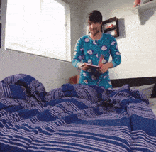 a man in a blue pajamas is standing on a bed