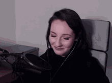 a woman wearing headphones is sitting in front of a microphone .
