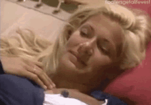 a blonde woman is laying on a bed with her eyes closed and the words " floatersgetalifevest " on the bottom right