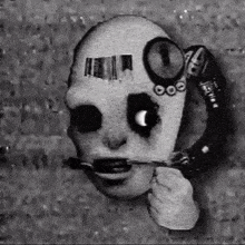 a black and white drawing of a scary face with a telephone in its mouth .