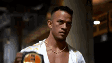 a man wearing a pearl necklace is holding a belt that says ecw