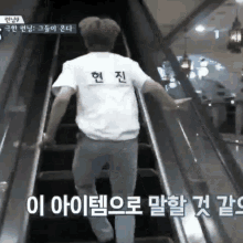 a man in a white shirt is walking up a set of escalators