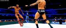 two wrestlers are fighting in a wrestling ring with the word w on the ring rope