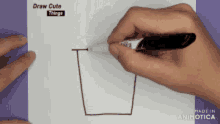 a person is drawing a cup with a marker on a piece of paper that says draw cute things