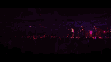 a woman singing into a microphone with her hands up in the air