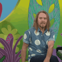a man with long hair and a polka dot shirt